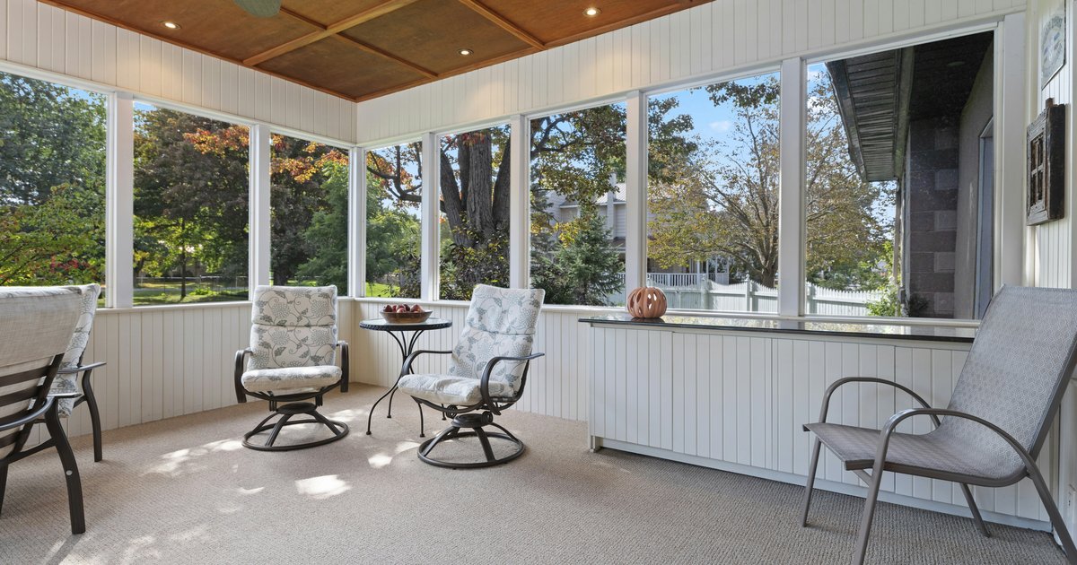Screened sunroom porch with outdoor chairs and ceiling fan